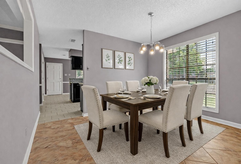 Dining area featuring hanging lights, a textured ceiling, and light tile patterned flooring