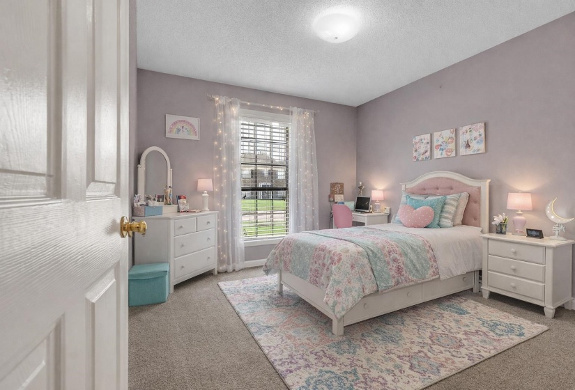 Bedroom with light colored carpet and a textured ceiling