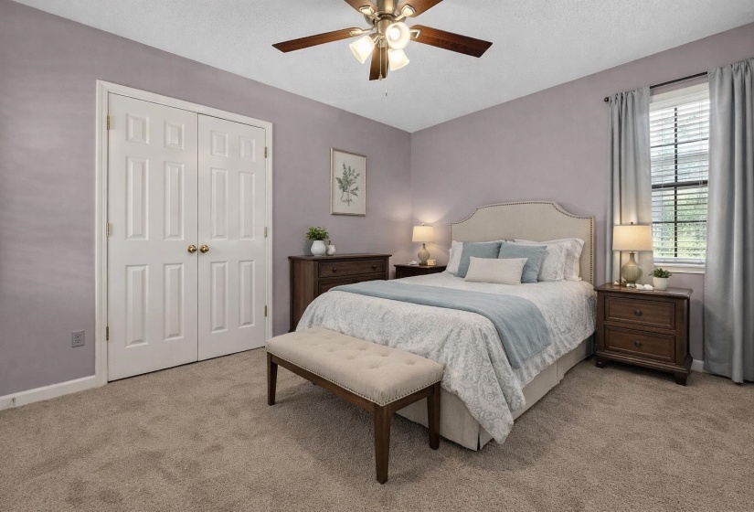 Bedroom with light colored carpet, a ceiling fan, a textured ceiling, and a closet