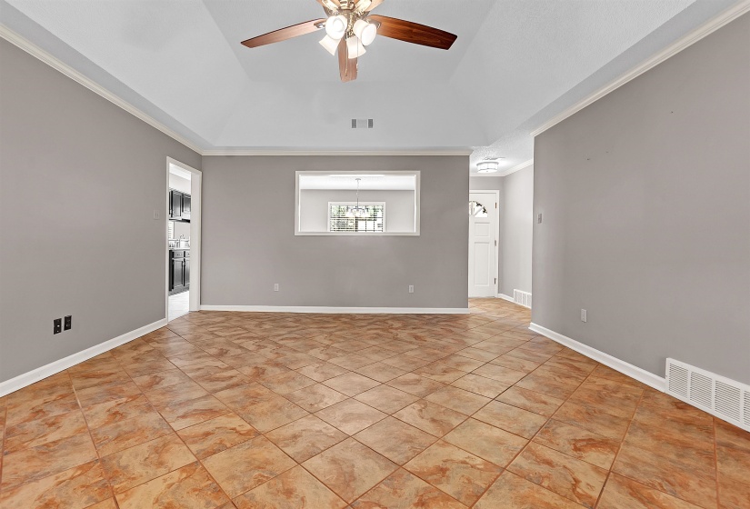 Spare room with ornamental molding, a ceiling fan, and a raised ceiling