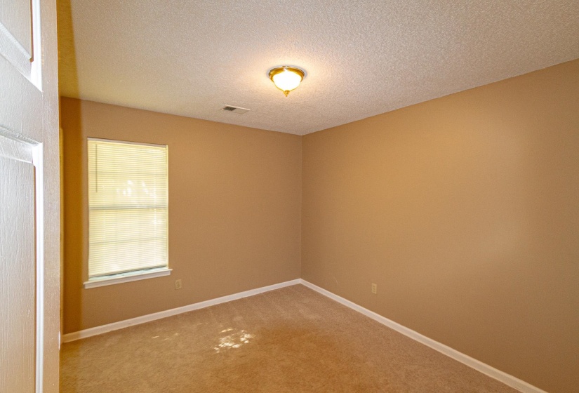 Carpeted empty room with baseboards and a textured ceiling