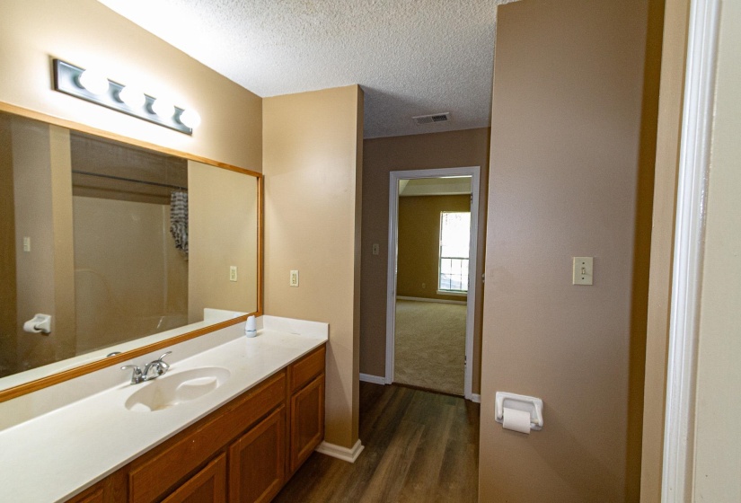 Full bathroom with vanity, dark wood finished floors, a textured ceiling, and a shower with shower curtain