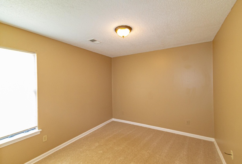 Unfurnished room with light colored carpet and a textured ceiling