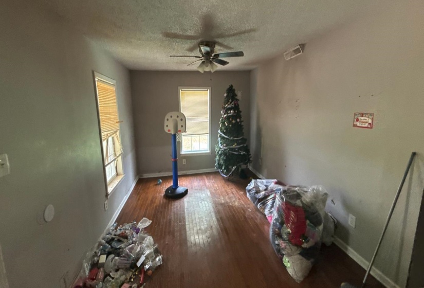 Unfurnished dining area featuring dark wood-type flooring, a textured ceiling, and ceiling fan