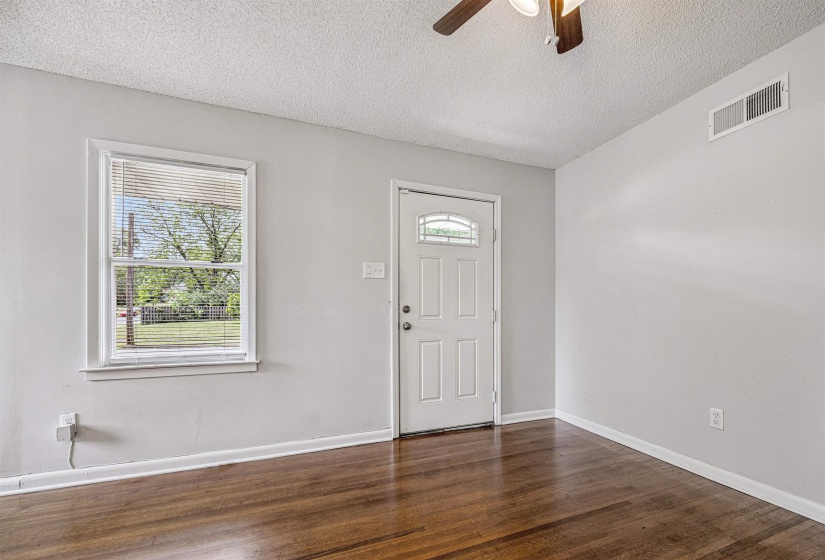Foyer entrance featuring a textured ceiling, dark wood-style floors, and a ceiling fan