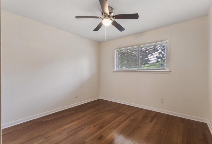 Spare room with dark wood-type flooring and ceiling fan