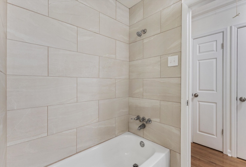 Bathroom with shower / bath combination and wood finished floors