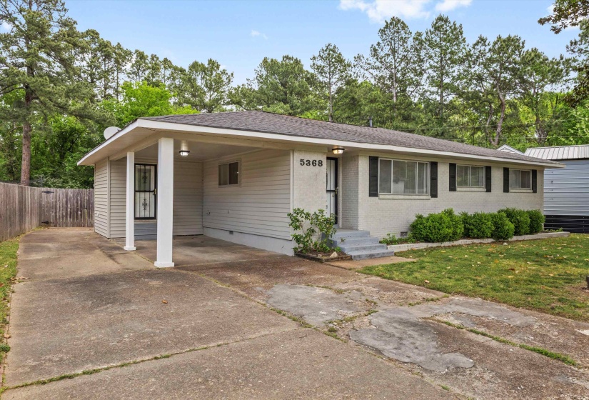 View of front of house featuring driveway, a carport, crawl space, brick siding, and roof with shingles