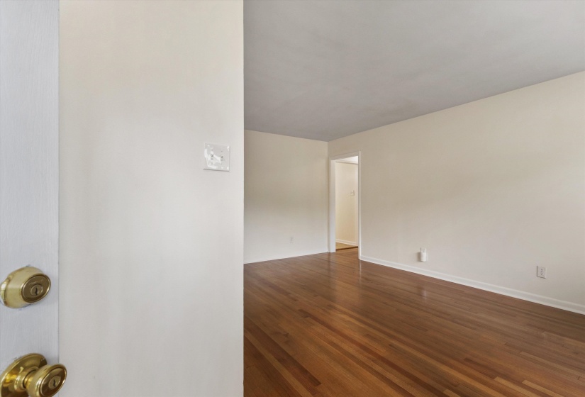 Unfurnished room with dark wood-style floors and baseboards