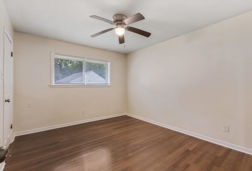 Unfurnished bedroom featuring ceiling fan and dark wood-style flooring