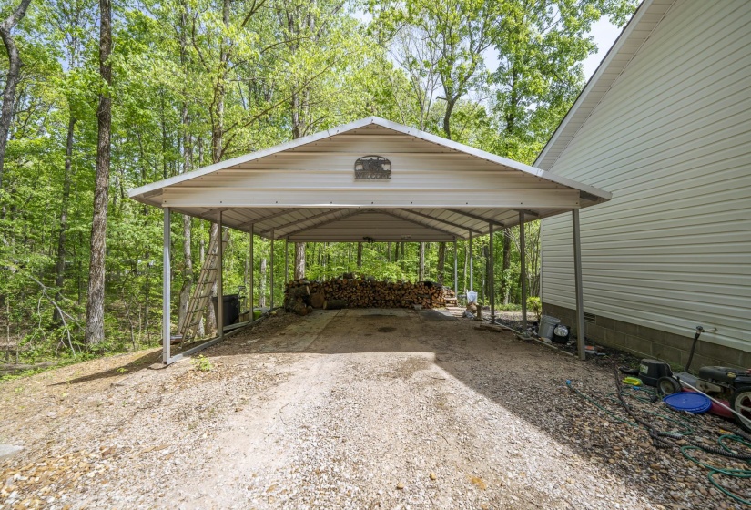 View of parking featuring a detached carport and driveway