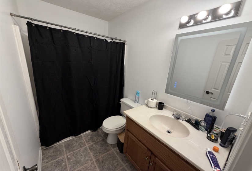 Full bath featuring vanity, a shower with shower curtain, and a textured ceiling