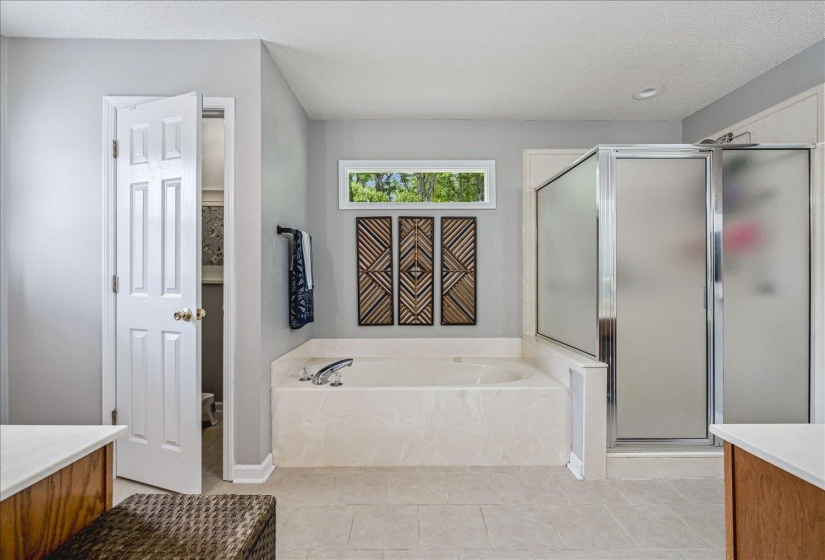 Full bathroom with a stall shower, vanity, a garden tub, and light tile patterned flooring
