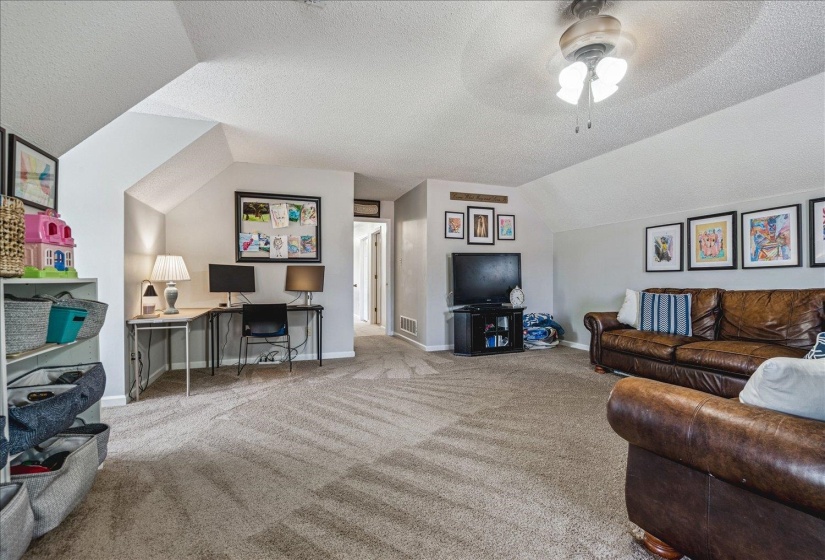 Carpeted living area featuring baseboards and a ceiling fan
