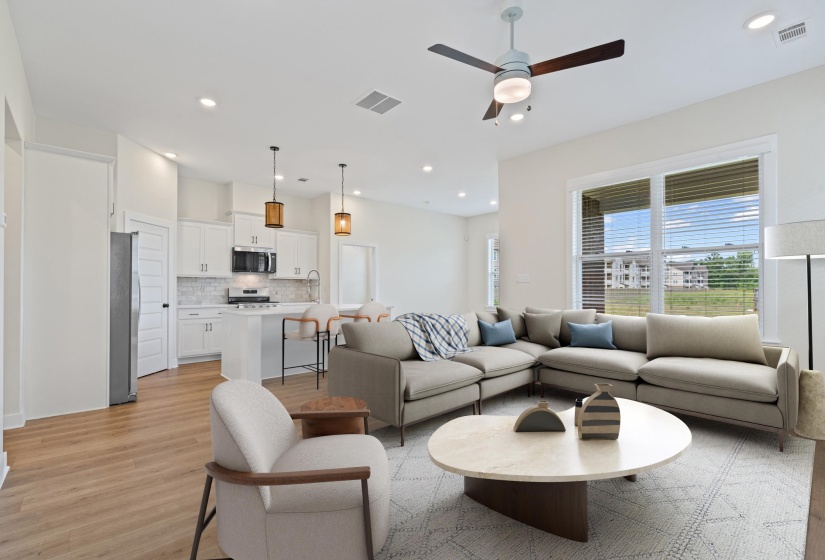 Open-concept living space featuring wood-finish flooring, recessed lighting, and a ceiling fan