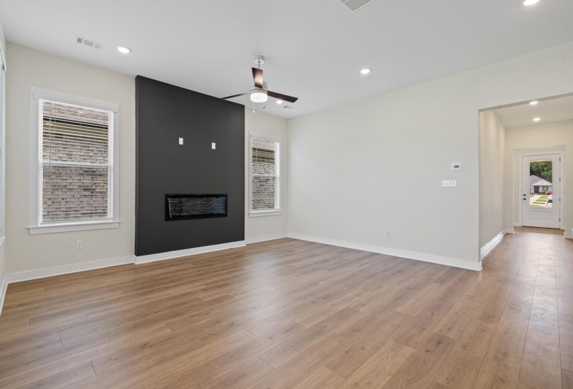 Open-concept living area featuring wood-finish flooring, recessed lighting, and a modern ceiling fan