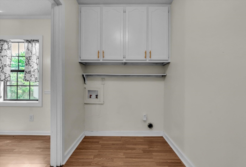 Laundry area featuring cabinet space, light wood-style floors, and washer hookup