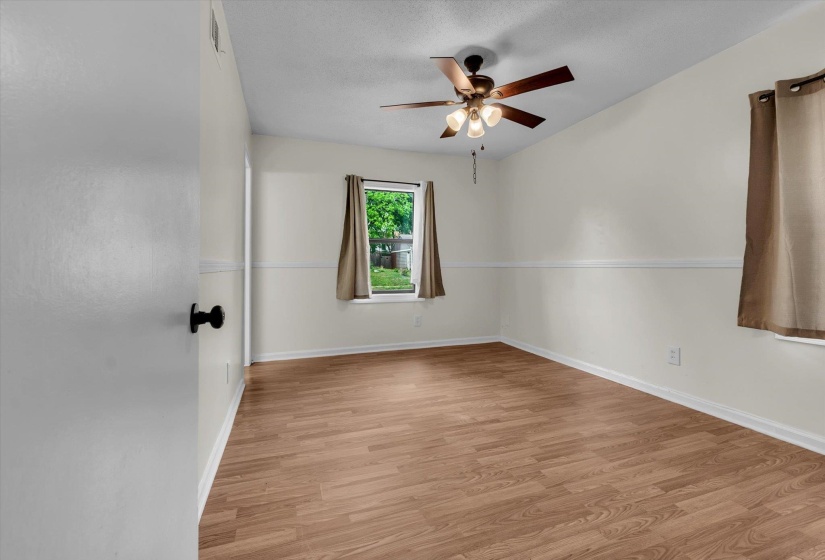 Empty room with light wood-style flooring and ceiling fan