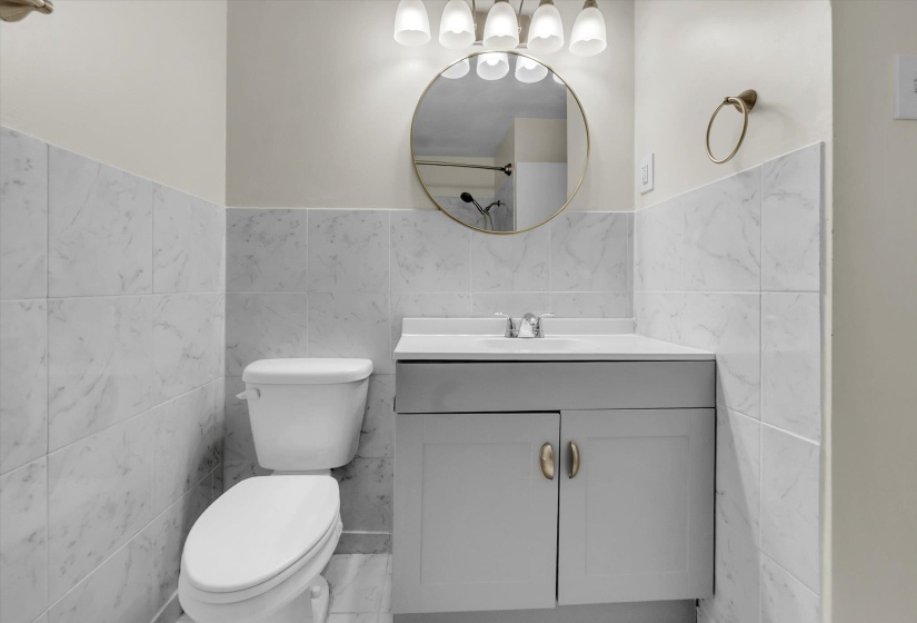 Bathroom featuring vanity, tile walls, and a wainscoted wall