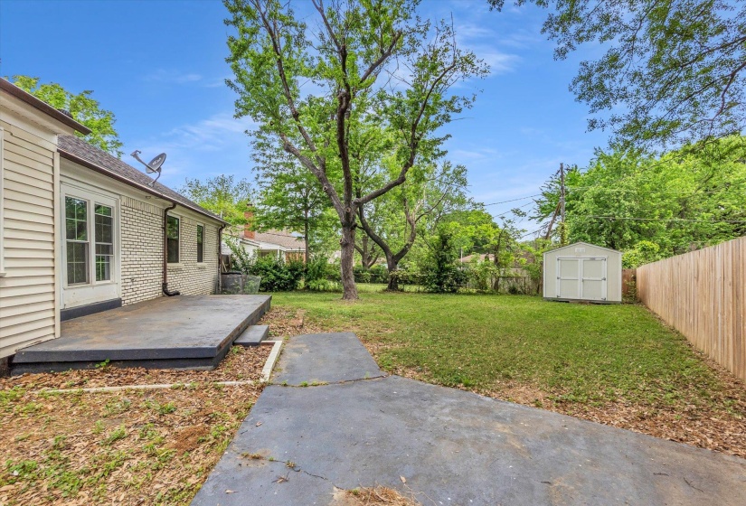 Fenced backyard with a shed and a deck