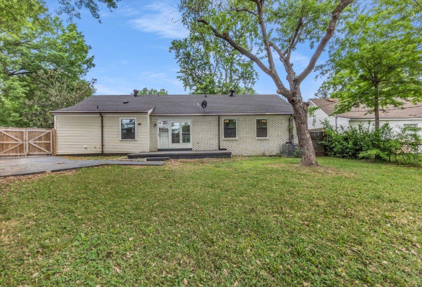 Rear view of house featuring a gate, a fenced backyard, and a deck