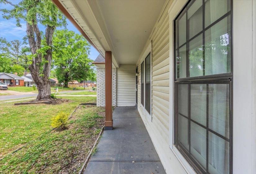 Covered porch featuring a yard and a residential view