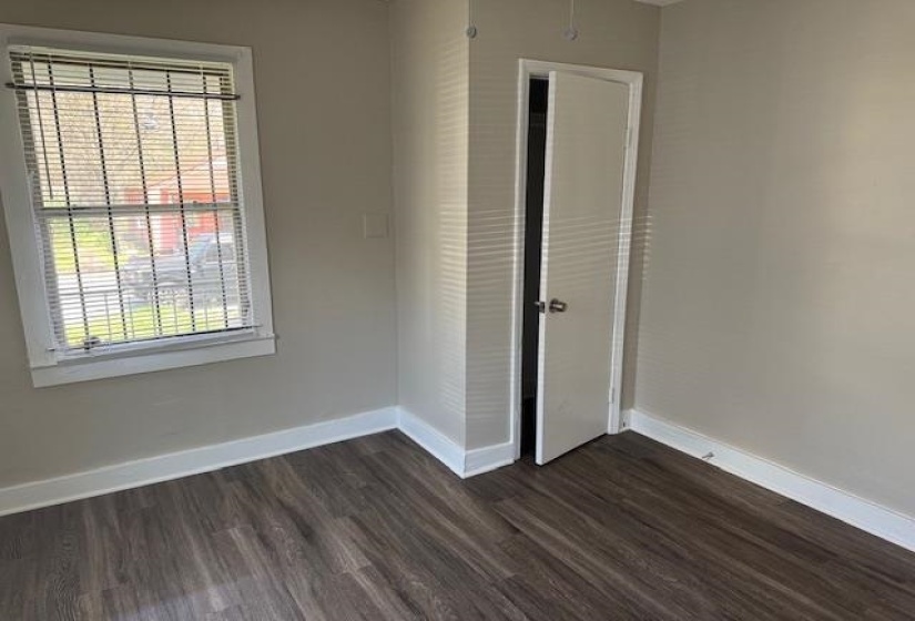 Unfurnished bedroom with baseboards and dark wood-style floors