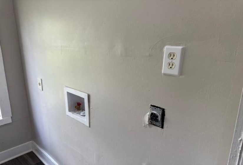 Washroom with washer hookup, baseboards, and dark wood finished floors