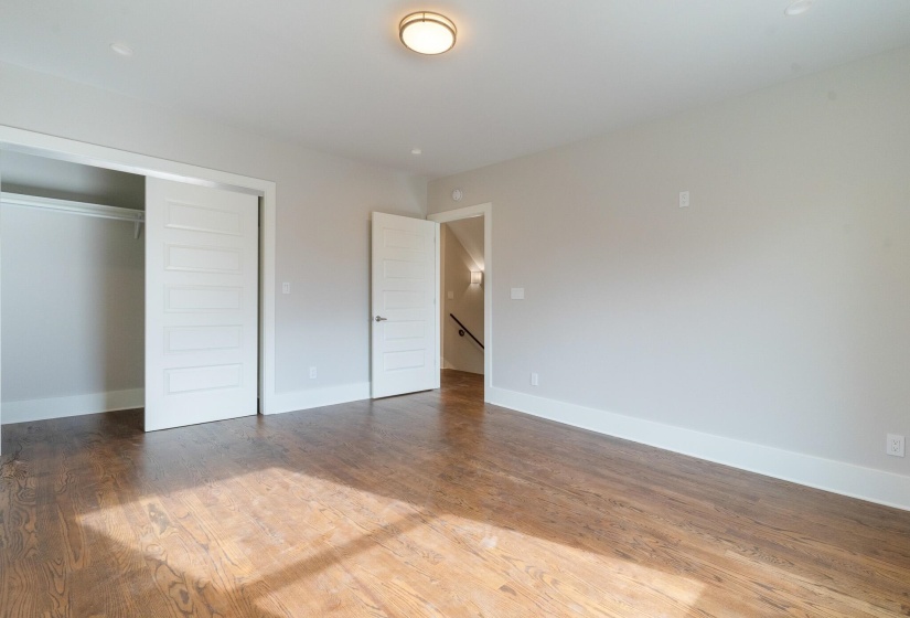 Unfurnished bedroom featuring wood finished floors and a closet