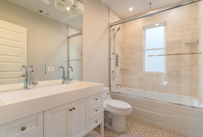 Bathroom with a combined bath / shower with rainfall shower, vanity, and tile patterned floors