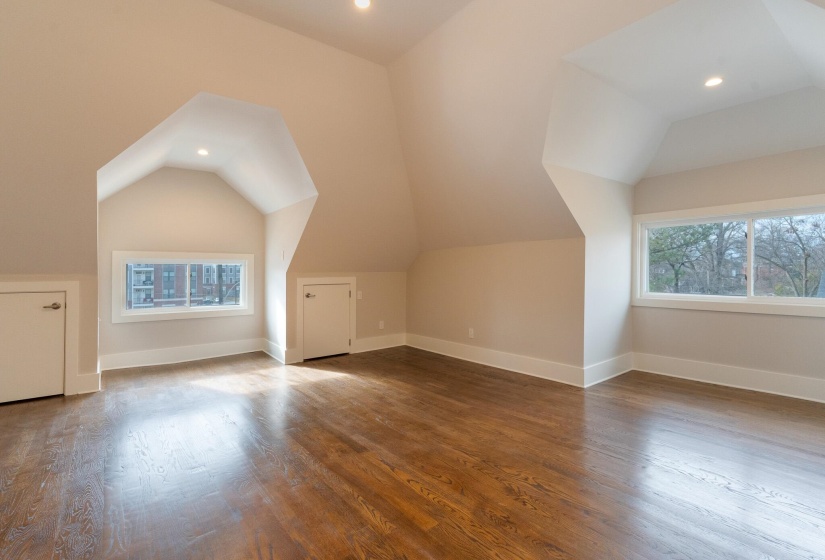 Additional living space with lofted ceiling, wood finished floors, and recessed lighting