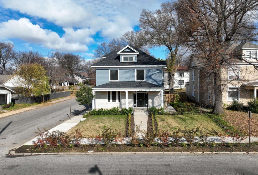 American foursquare style home with a porch and a shingled roof