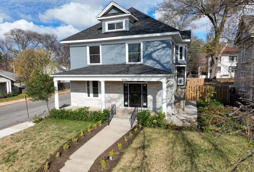 American foursquare style home featuring a porch and roof with shingles