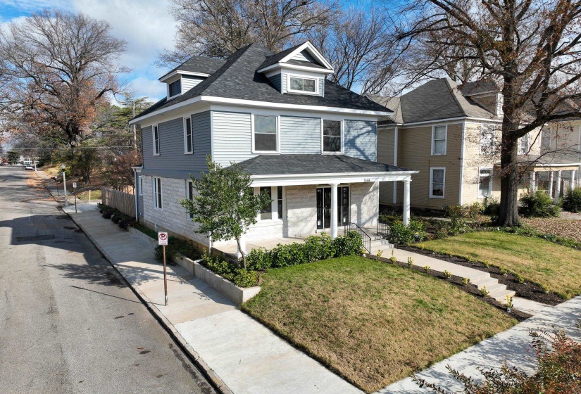 Traditional style home featuring covered porch, a front lawn, and roof with shingles