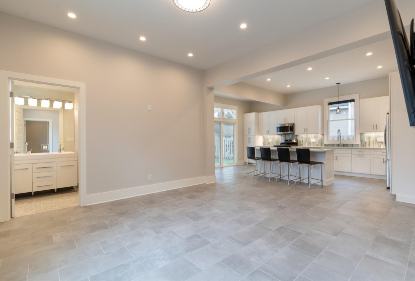 Kitchen featuring white cabinetry, a center island, a breakfast bar, recessed lighting, and decorative backsplash