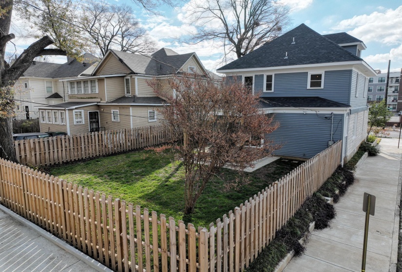 View of front of home with roof with shingles, a fenced backyard, and a residential view