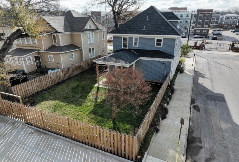 Back of property featuring a shingled roof, a residential view, and a fenced backyard