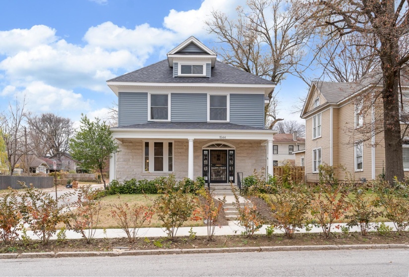 American foursquare style home featuring a porch and roof with shingles