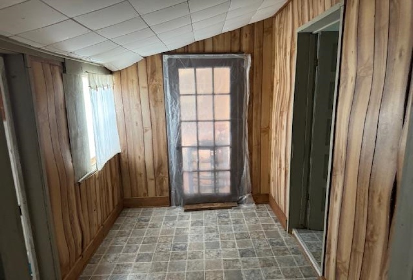 Entryway with vaulted ceiling and wooden walls