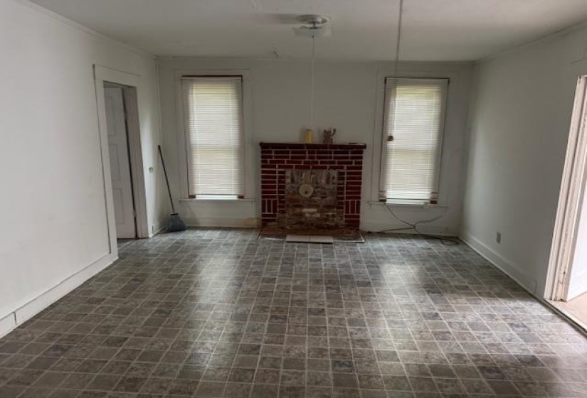 Unfurnished living room featuring baseboards