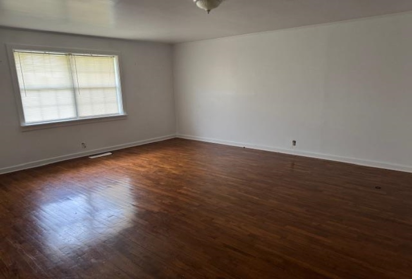 Unfurnished room featuring dark wood finished floors and baseboards