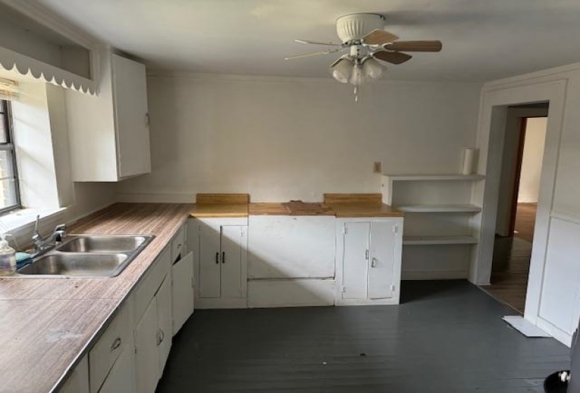 Kitchen with white cabinetry, light countertops, and a ceiling fan