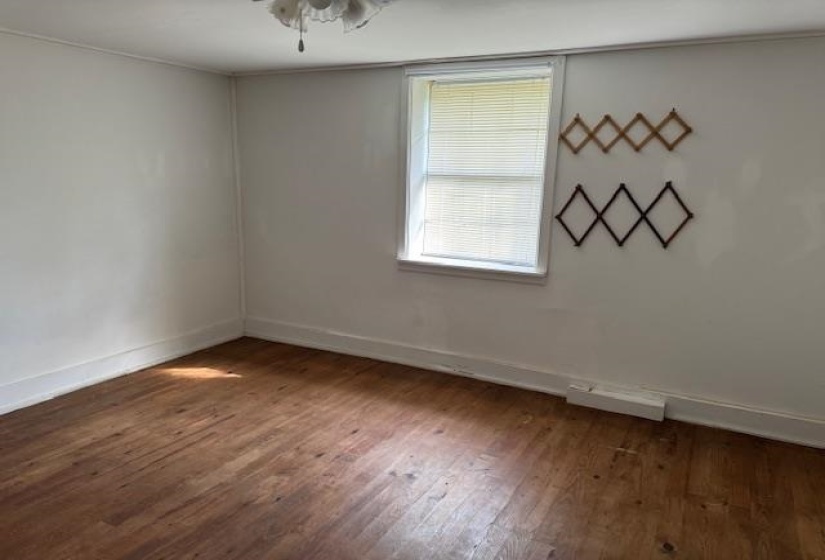 Unfurnished room featuring baseboards and dark wood-type flooring