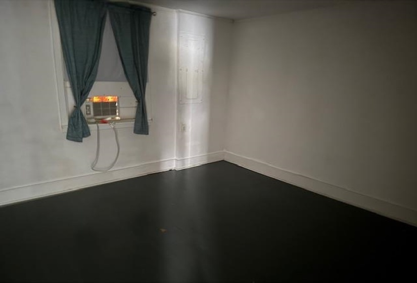 Unfurnished room featuring finished concrete flooring and baseboards