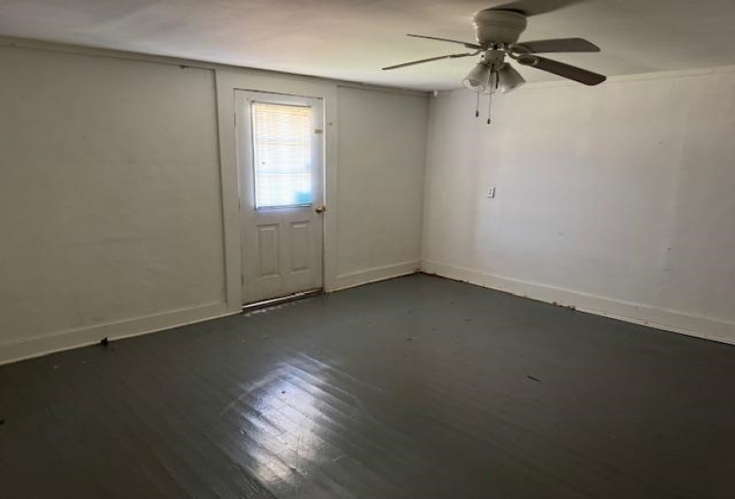 Empty room with ceiling fan and dark wood-style floors