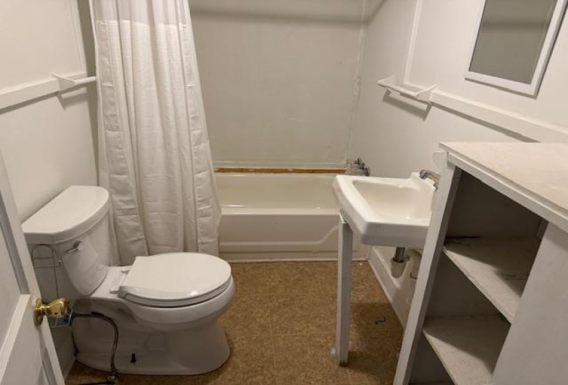 Full bath featuring toilet and shower / bath combination with curtain