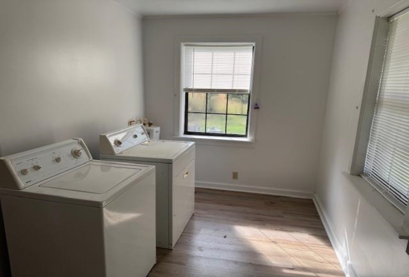 Laundry room featuring light wood-type flooring and washing machine and clothes dryer