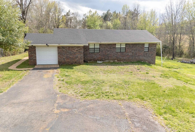 Ranch-style home with brick siding, driveway, a garage, and a front yard