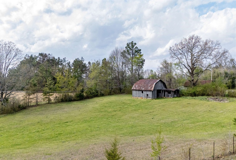 View of yard featuring a barn, an outdoor structure, and a rural view