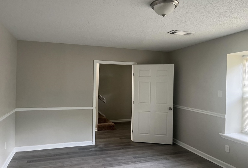 Unfurnished bedroom featuring dark wood finished floors and a textured ceiling